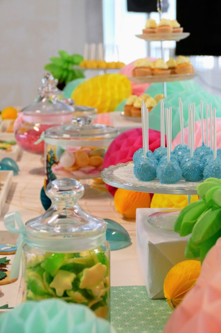Bar à pâtisseries par Studio Candy pour L'Oréal - cake pops bleus, soucoupes, sablés décorés tongs, tortue, ananas, cupcakes