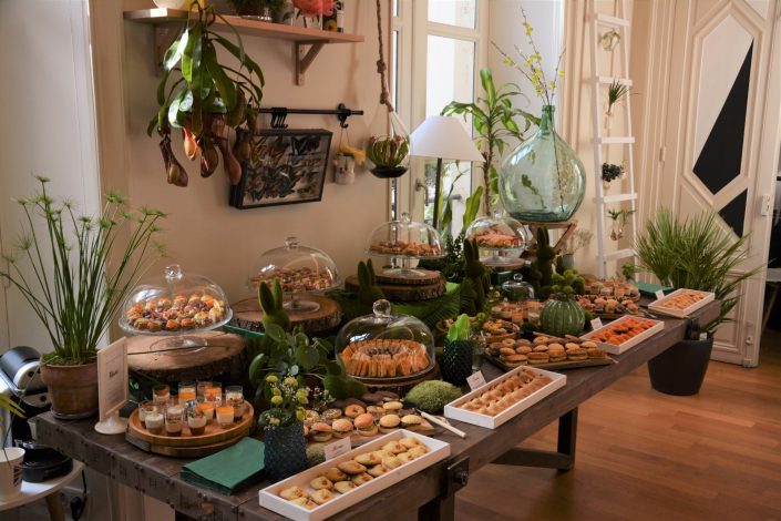 Table thème nature pour Au Féminin par Studio Candy - lapins en mousse, cloches en verre, feuilles tropicales, rondins de bois, bonbonne géante, mini verrines