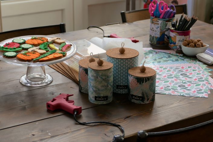 Atelier diy - atelier créatif chez Au Féminin pour D'aucy - boites de rangement réalisées avec des boites de conserve, pistolet à colle, papiers à motifs, perles de liège, ciseaux