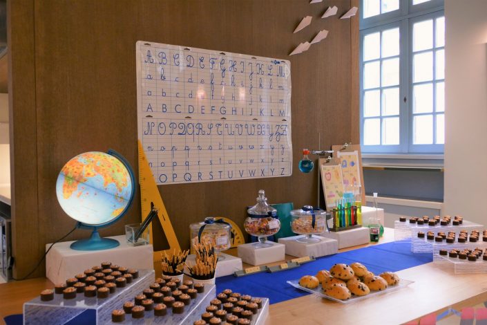Sweet table back to school par Studio Candy pour Kering - sucettes, brioches, tartelettes au carambar, mikado, globe terrestre, colliers de bonbons