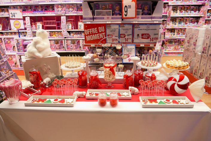 Bar à bonbons Noël chez Toys 'R Us par Studio Candy - sablés décorés moufle, flocon, bonnet de père noel, noeud rouge, sucre d'orge, sucettes, cake pops blancs, cupcakes