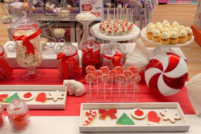 Bar à bonbons Noël chez Toys 'R Us par Studio Candy - sablés décorés moufle, flocon, bonnet de père noel, noeud rouge, sucre d'orge, sucettes, cake pops blancs