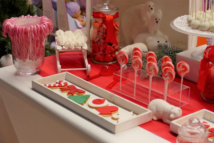 Bar à bonbons Noël chez Toys 'R Us par Studio Candy - sablés décorés moufle, flocon, bonnet de père noel, noeud rouge, sucettes, meringues, cake pops blancs