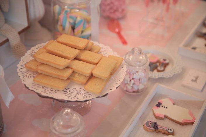 Sweet table thème Baby Shower par Studio Candy pour l'événement presse de Babies'R Us - sablés décorés biberon, tétine, ourson, body, bavoir