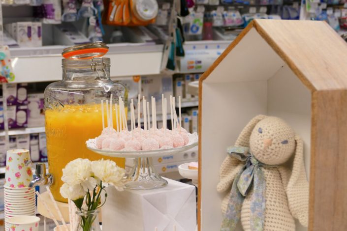 Sweet table thème bébé pour le magasin Toys'R Us de la Défense. Scénographie par Studio Candy. Cake pops roses, financiers, jus d'orange, viennoiseries, sablés décorés poussette, chausson, bavoir, body... et décoration thème Baby Shower