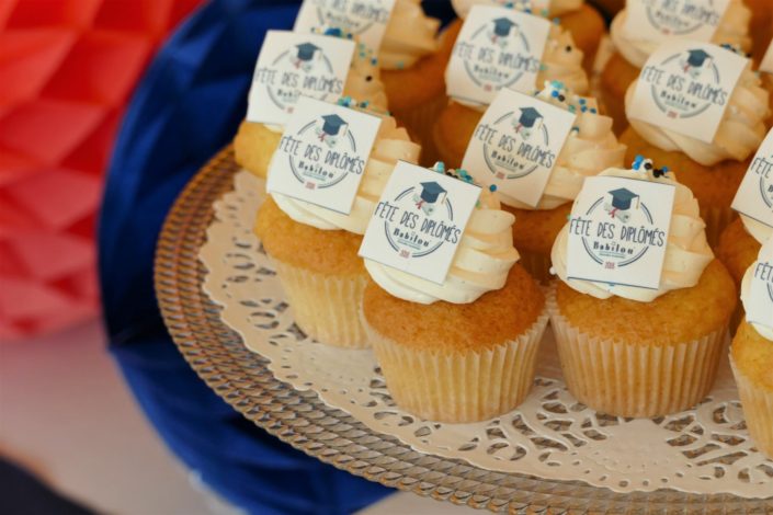 Fête des diplômés chez Babilou par Studio Candy - Sweet table, candy bar bleu, blanc et corail - Sablés décorés diplômes, toge, bonbons, sucettes, cupcakes avec logo, décoration