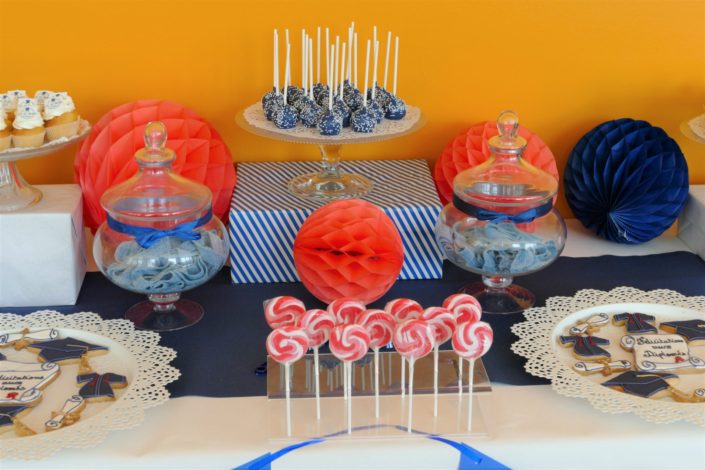 Fête des diplômés chez Babilou par Studio Candy - Sweet table, candy bar bleu, blanc et corail - Sablés décorés diplômes, toge, bonbons, sucettes, cupcakes avec logo, décoration