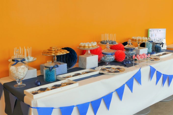 Fête des diplômés chez Babilou par Studio Candy - Sweet table, candy bar bleu, blanc et corail - Sablés décorés diplômes, toge, bonbons, sucettes, cupcakes avec logo, décoration