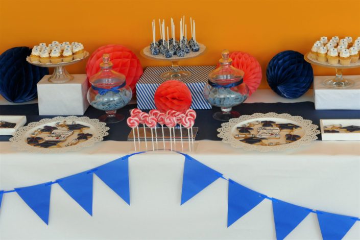 Fête des diplômés chez Babilou par Studio Candy - Sweet table, candy bar bleu, blanc et corail - Sablés décorés diplômes, toge, bonbons, sucettes, cupcakes avec logo, décoration