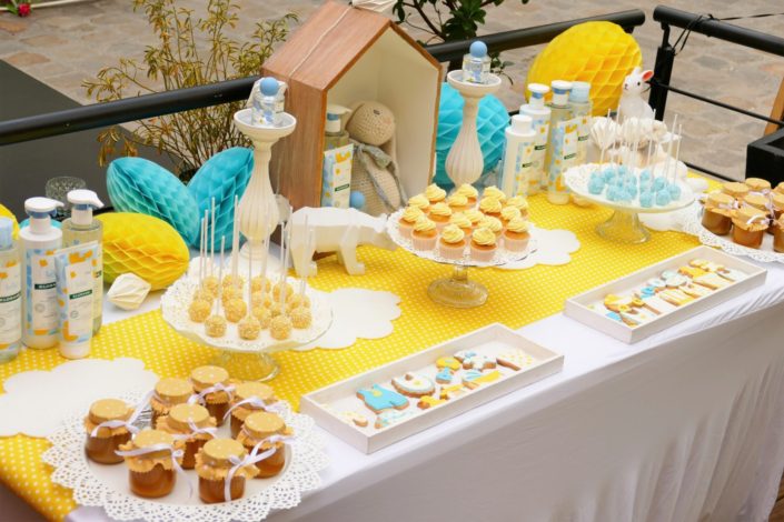 Sweet table / table goûter décorée par Studio Candy pour le lancement de la gamme bébé Klorane chez Au Féminin - sablés décorés, cake pops, petits pots de bébés, décoration jaune et bleue