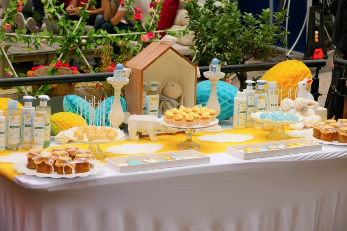 Sweet table / table goûter décorée par Studio Candy pour le lancement de la gamme bébé Klorane chez Au Féminin - sablés décorés, cake pops, petits pots de bébés, décoration jaune et bleue