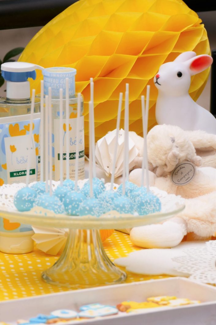 Sweet table / table goûter décorée par Studio Candy pour le lancement de la gamme bébé Klorane chez Au Féminin - sablés décorés, cake pops, petits pots de bébés, décoration jaune et bleue