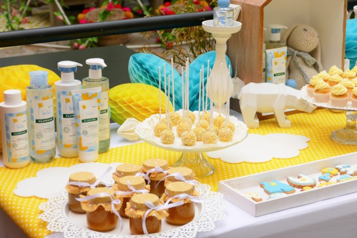 Sweet table / table goûter décorée par Studio Candy pour le lancement de la gamme bébé Klorane chez Au Féminin - sablés décorés, cake pops, petits pots de bébés, décoration jaune et bleue