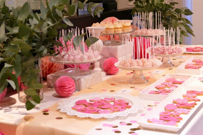 Sweet table / Bar à pâtisseries par Studio Candy chez Estée Lauder à l'occasion d'octobre rose. Sablés décorés roses, cakepops, cupcakes, décoration rose, blanche et eucalyptus, confettis.