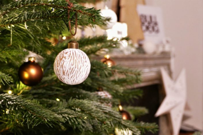 Scénographie, décoration de Noël pour la marque Bulldog par Studio Candy - sapin, table branche de sapin et pomme de pin, cheminée décorée