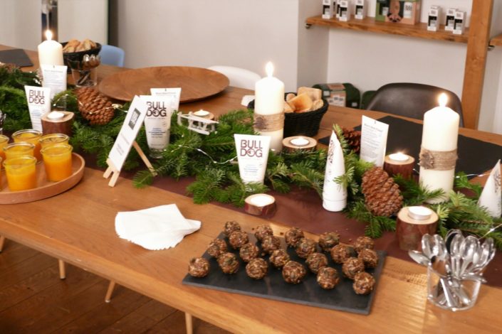 Scénographie, décoration de Noël pour la marque Bulldog par Studio Candy - sapin, table branche de sapin et pomme de pin, cheminée décorée