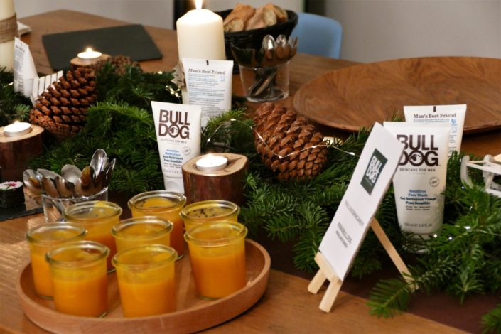 Scénographie, décoration de Noël pour la marque Bulldog par Studio Candy - sapin, table branche de sapin et pomme de pin, cheminée décorée