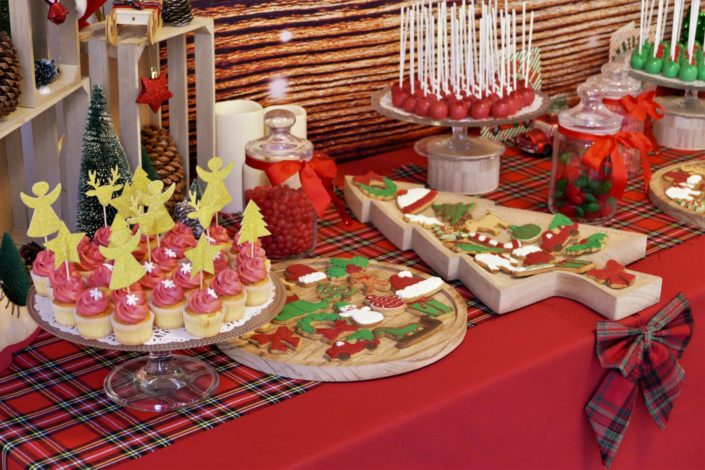 Goûter de Noël par Studio Candy chez Estée Lauder - Candy Bar / Bar à bonbons et pâtisseries - sablés décorés de Noël sucre d'orge, luge, bonnet de père noel, bonhomme de pain d'épice, ours polaire. Cake pops au chocolat, cupcakes, sapins meringue décorés. Décoration rouge vintage et tartan écossais avec sapin, patin à glace, petit train, pommes de pin