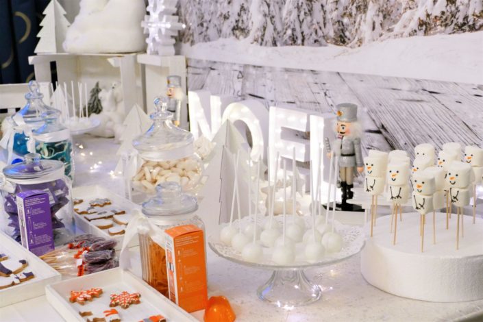 Candy bar noel chez Clinique réalisé par Studio Candy - brochette de chamallows bonhommes de neige, sablés décorés produit Clinique ID et thème Noël : ours polaire, moufle, gant, bonnet, sapin, flocon. Cake pops au chocolat, sapins meringue. Décoration polaire en blanc et argent.