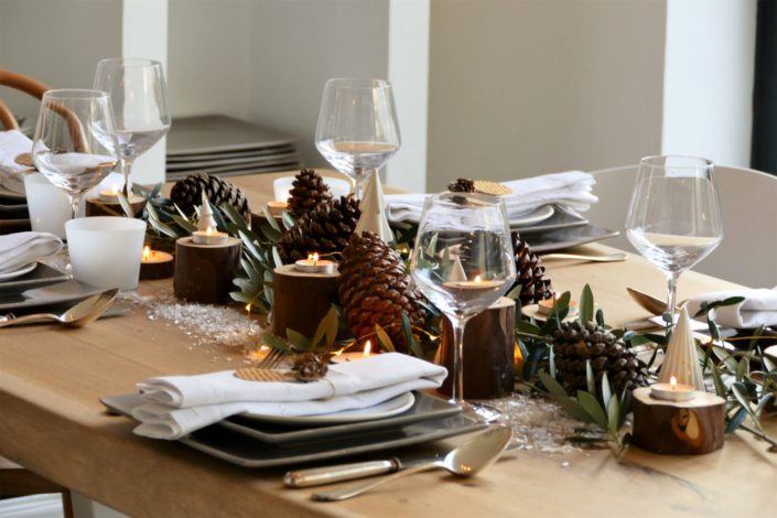 Set design / Art de la table / décoration table de noël par Studio Candy pour For me Lab - branches d'olivier, rondins de bois, bougies, pommes de pin, serviettes en lin, argenterie vintage