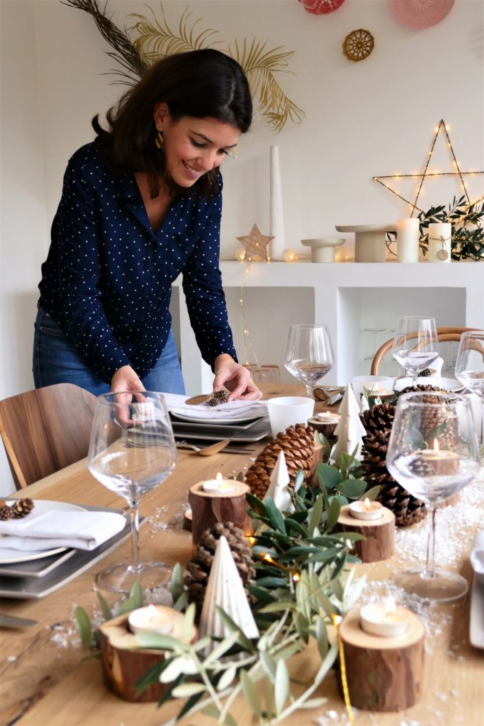 Set design / Art de la table / décoration table de noël par Studio Candy pour For me Lab - branches d'olivier, rondins de bois, bougies, pommes de pin, serviettes en lin, argenterie vintage
