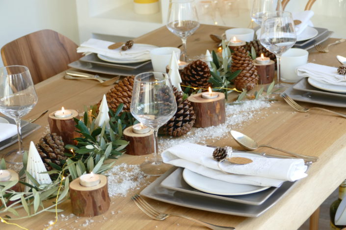 Set design / Art de la table / décoration table de noël par Studio Candy pour For me Lab - branches d'olivier, rondins de bois, bougies, pommes de pin, serviettes en lin, argenterie vintage