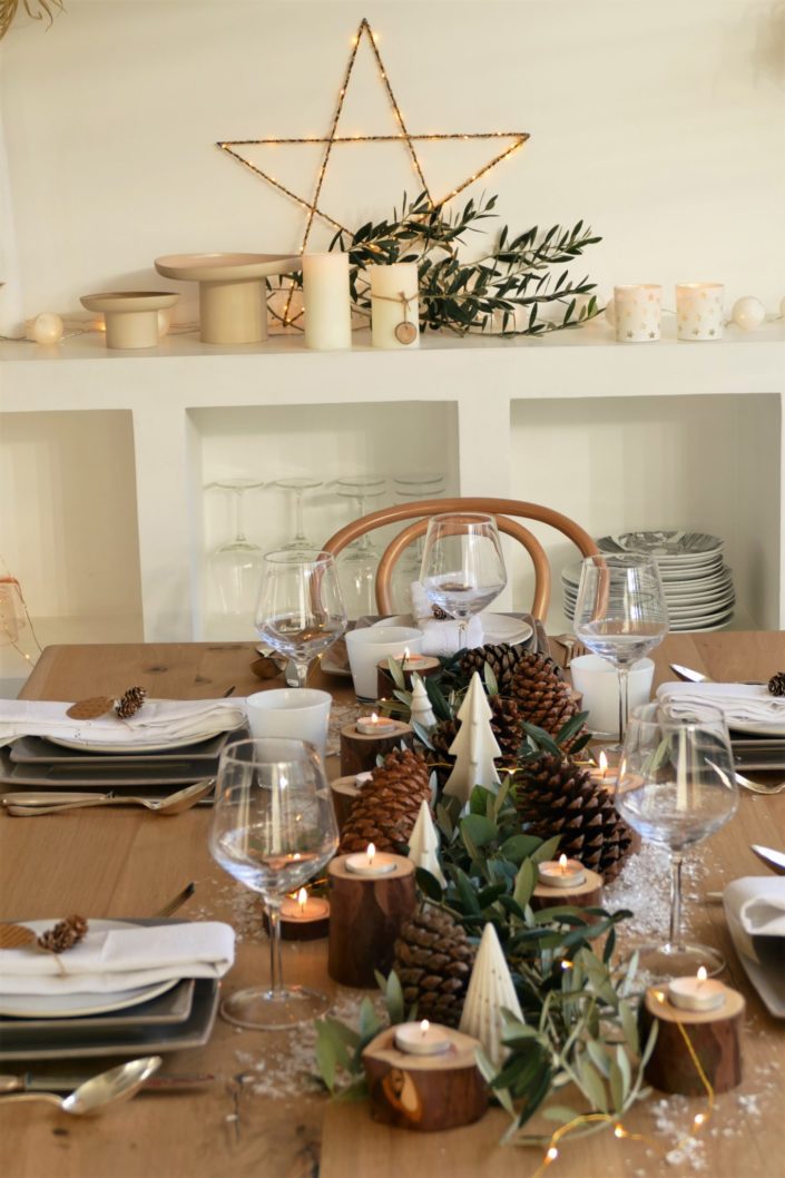 Set design / Art de la table / décoration table de noël par Studio Candy pour For me Lab - branches d'olivier, rondins de bois, bougies, pommes de pin, serviettes en lin, argenterie vintage