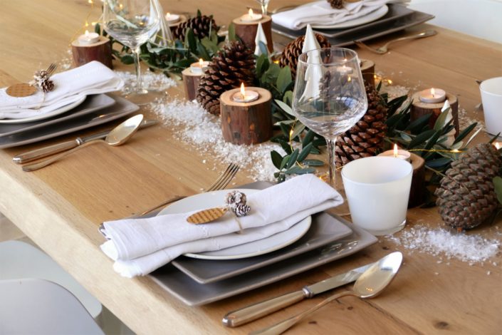 Set design / Art de la table / décoration table de noël par Studio Candy pour For me Lab - branches d'olivier, rondins de bois, bougies, pommes de pin, serviettes en lin, argenterie vintage