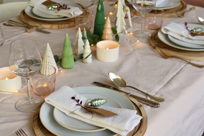 Set design / Art de la table / décoration table de noël par Studio Candy pour For me Lab - nappe ne lin rose pastel, set de table en bois, étiquette kraft, décoration en verre, sapins en céramique, serviettes en lin, argenterie vintage