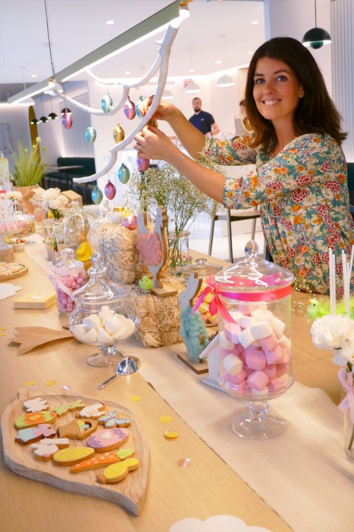 Goûter de Pâques naturel et pastel avec bottes de foin, oeufs en chocolat, bonbons, cake pops, fleurs, lapins et poules, nids meringue, sablés décorés