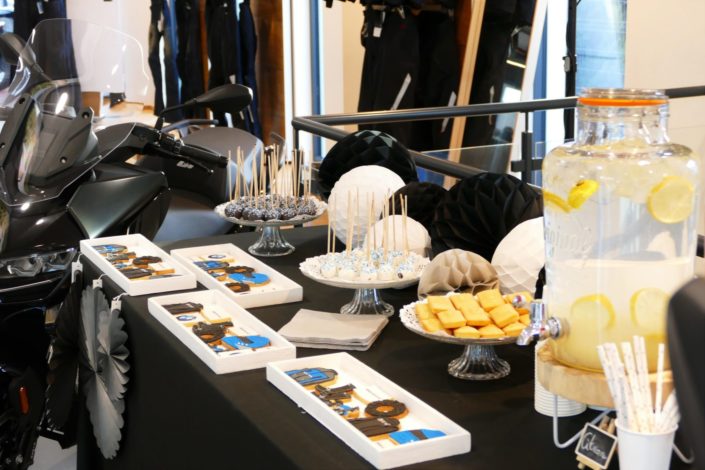 concession BMW - événement sweet table goûter par Studio Candy - sablés décorés moto, roue, blouson, casque de moto, cake pop noir et blanc, financiers et fontaines à boissons