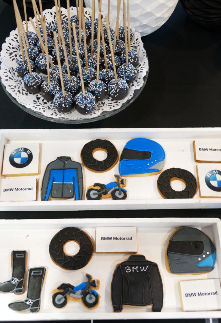 concession BMW - événement sweet table goûter par Studio Candy - sablés décorés moto, roue, blouson, casque de moto, cake pop noir et blanc, financiers et fontaines à boissons