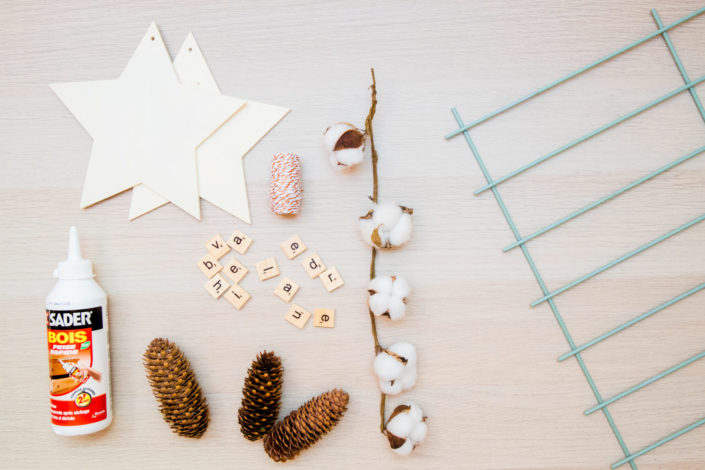 DIY décor d'hiver réalisé par Studio Candy pour Sader - étoiles en bois, fleurs de coton, colle, pommes de pin, décoration.