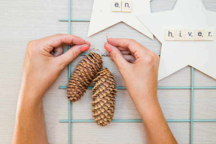 DIY décor d'hiver réalisé par Studio Candy pour Sader - étoiles en bois, fleurs de coton, colle, pommes de pin, décoration.