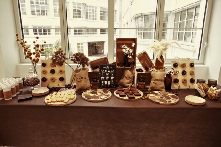 goûter thème café avec décoration, sacs de jute, grains de café, cannelle, vases fleurs de coton, financiers amande, brownie, donuts chocolat, sablés décorés