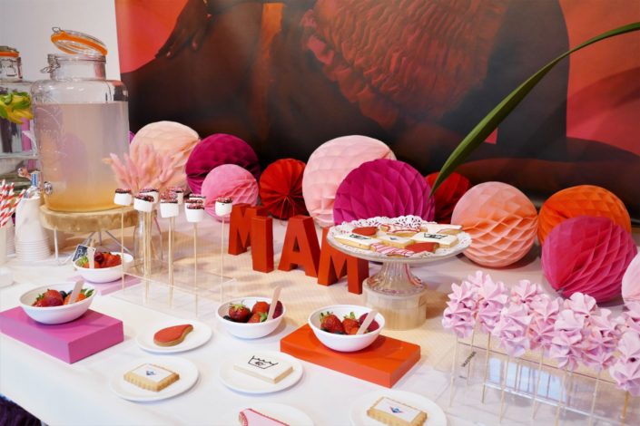 Table gourmande avec meringue rose, chamallows au chocolat, petits sablés culotte, goutte et bols de fruits rouges. Décoration rouge et rose - Studio Candy