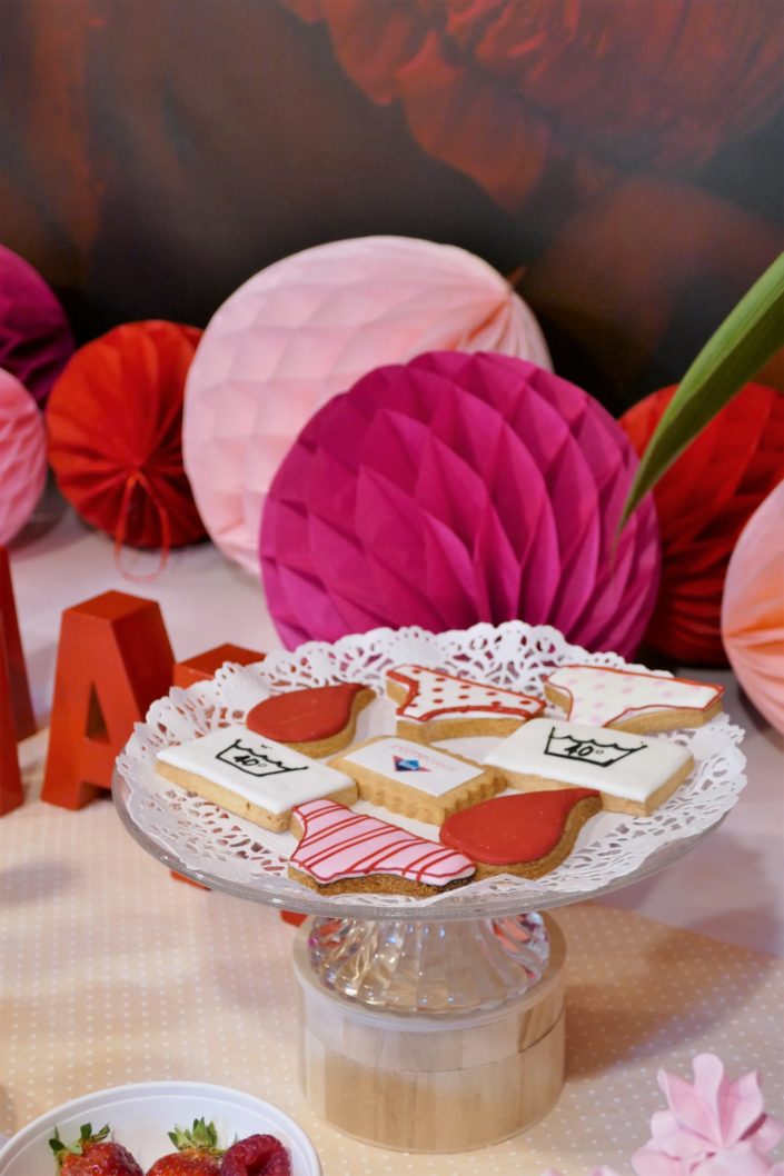 Table gourmande avec meringue rose, chamallows au chocolat, petits sablés culotte, goutte et bols de fruits rouges. Décoration rouge et rose - Studio Candy