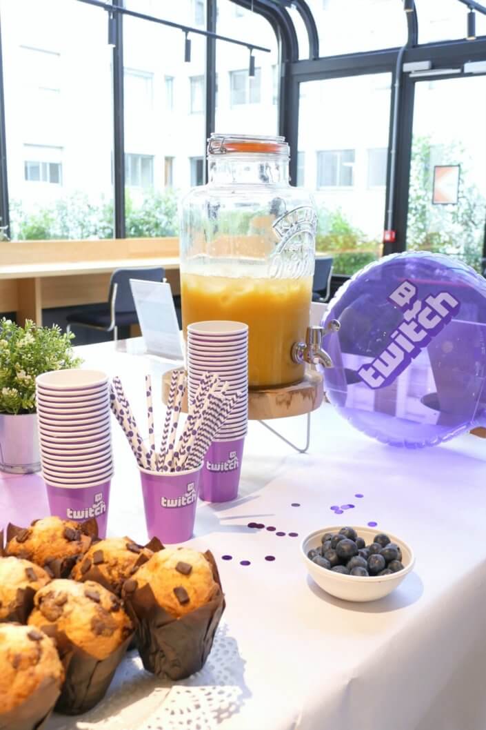 gouter_twitch_violet et blanc avec sables decores pacman, space invaders et ballons helium avec logo. Fontaine a boisson avec verres logotés. Animation en entreprise team building par Studio Candy