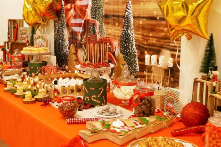 Goûter de Noël traditionnel avec petits sablés, cakepops rouges pailletés, chamallows bonhommes de neige, sapins meringue, petits oursons guimauve. Décoration en rouge, or, vert sapin avec des sucres d'orges, des bonbons, des sapins en bois