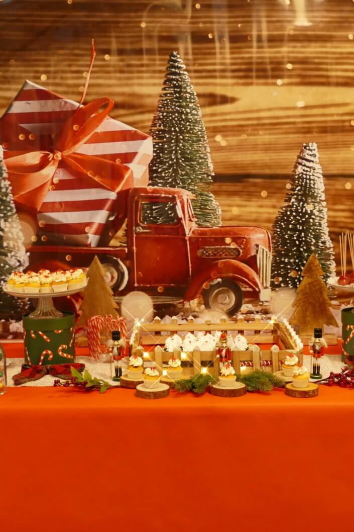 Goûter de Noël traditionnel avec petits sablés, cakepops rouges pailletés, chamallows bonhommes de neige, sapins meringue, petits oursons guimauve. Décoration en rouge, or, vert sapin avec des sucres d'orges, des bonbons, des sapins en bois