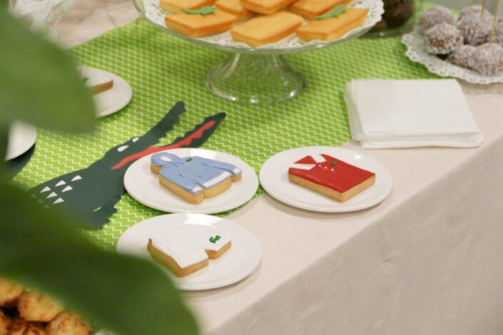 Goûter pour Lacoste avec sablés décorés short, polo, hoodies, casquette, balle de tennis. Cakepops verts, candy bar, financiers, boules coco et décoration crocodile en vert et blanc