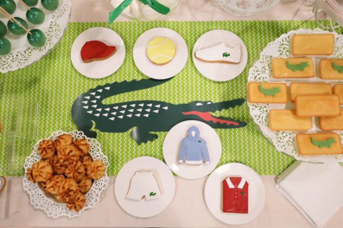 Goûter pour Lacoste avec sablés décorés short, polo, hoodies, casquette, balle de tennis. Cakepops verts, candy bar, financiers, boules coco et décoration crocodile en vert et blanc