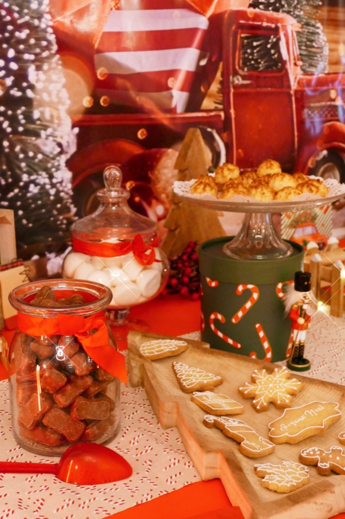 Goûter de Noël traditionnel avec sablés décorés, cake aux fruits, rochers coco, candy bar avec oursons guimauve, fraises tagada et décoration avec sapins, casse noisette, nœuds en tartan, sucres d'orge