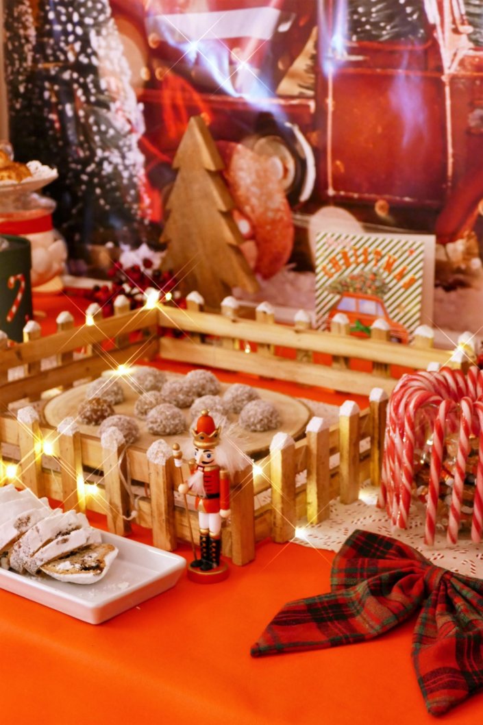 Goûter de Noël traditionnel avec sablés décorés, cake aux fruits, rochers coco, candy bar avec oursons guimauve, fraises tagada et décoration avec sapins, casse noisette, nœuds en tartan, sucres d'orge