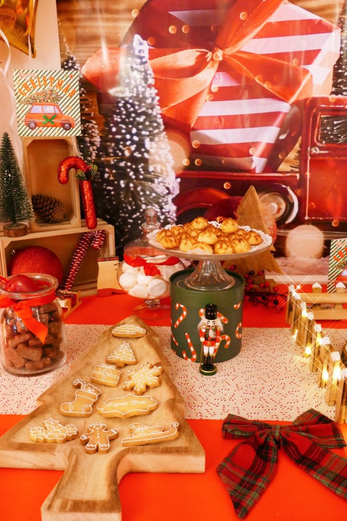 Goûter de Noël traditionnel avec sablés décorés, cake aux fruits, rochers coco, candy bar avec oursons guimauve, fraises tagada et décoration avec sapins, casse noisette, nœuds en tartan, sucres d'orge