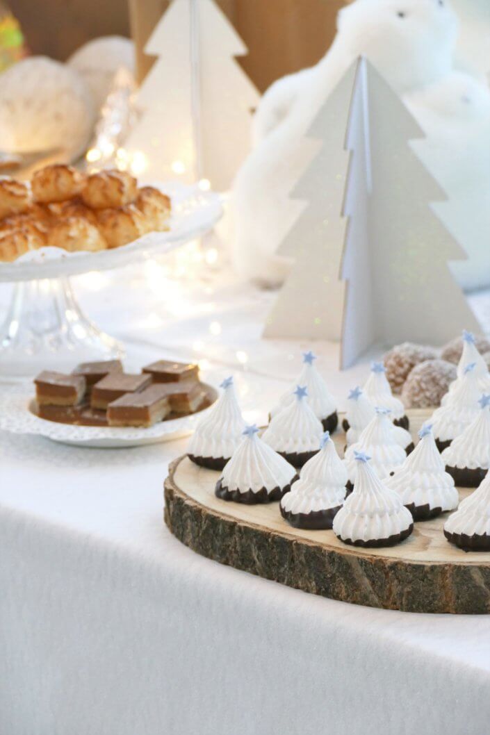 Goûter de Noël Polaire avec une décoration hiver enneigé en blanc : sapins pailletés, ours, pingouin, igloo. Fontaines à boissons, sapins meringue, financiers, sablés décorés de Noël