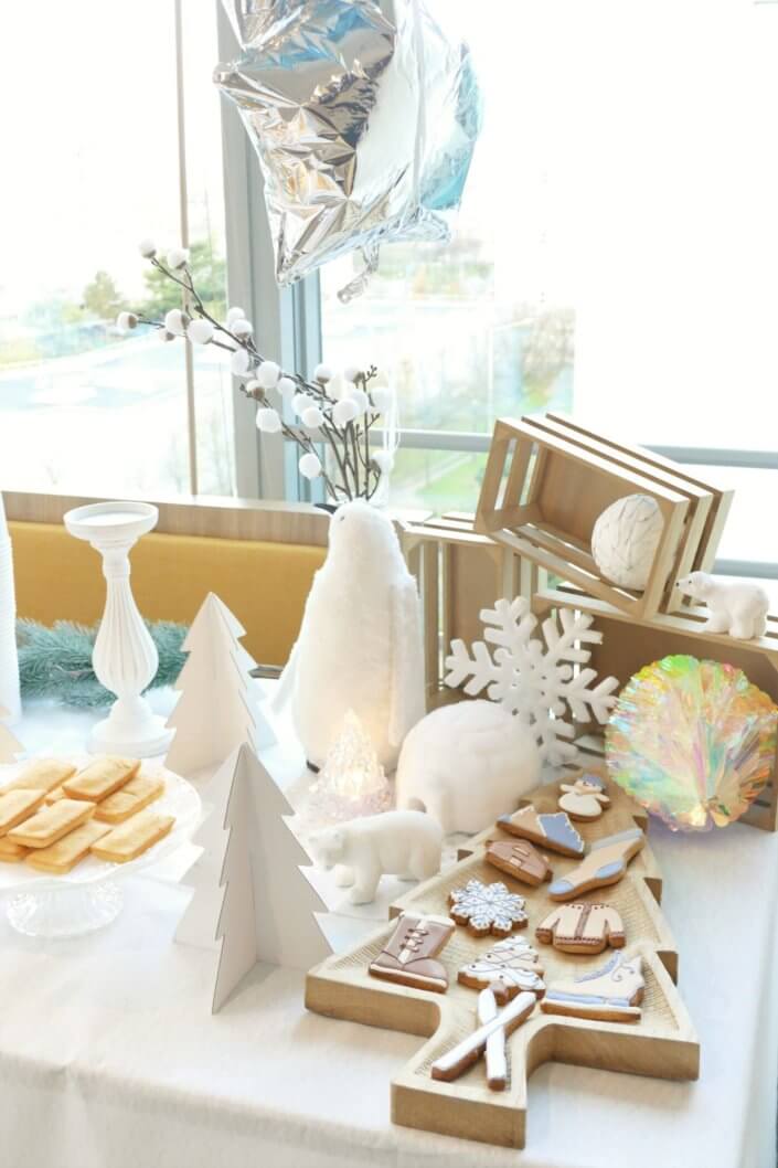 Goûter de Noël Polaire avec une décoration hiver enneigé en blanc : sapins pailletés, ours, pingouin, igloo. Fontaines à boissons, sapins meringue, financiers, sablés décorés de Noël