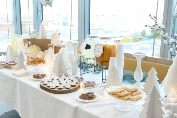 Goûter de Noël Polaire avec une décoration hiver enneigé en blanc : sapins pailletés, ours, pingouin, igloo. Fontaines à boissons, sapins meringue, financiers, sablés décorés de Noël