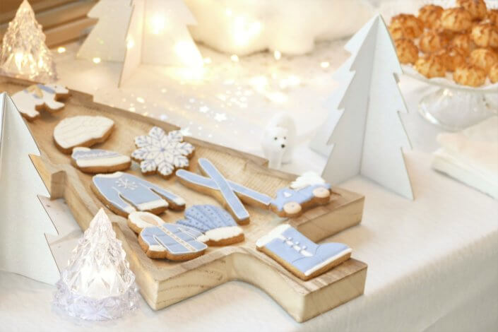 Goûter de Noël Polaire avec une décoration hiver enneigé en blanc : sapins pailletés, ours, pingouin, igloo. Fontaines à boissons, sapins meringue, financiers, sablés décorés de Noël