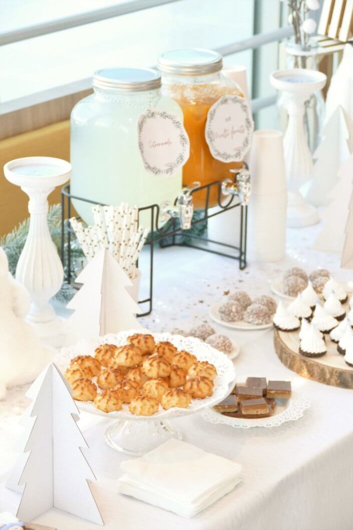 Goûter de Noël Polaire avec une décoration hiver enneigé en blanc : sapins pailletés, ours, pingouin, igloo. Fontaines à boissons, sapins meringue, financiers, sablés décorés de Noël